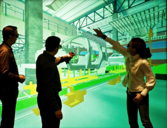 In einem virtuelen Raum Stehen drei Menschen mit Datenbrillen